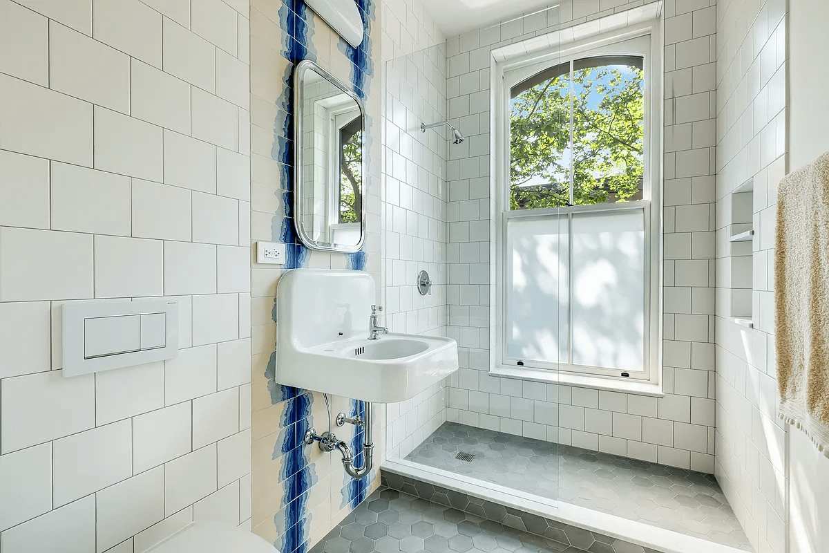 bath with white tile floor and blue pattern accent tiles