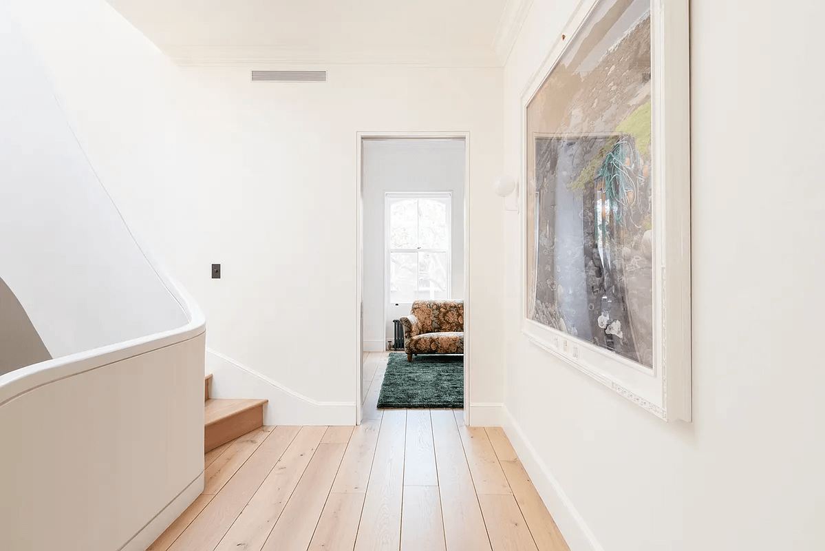 hall with wood floor and curved stair