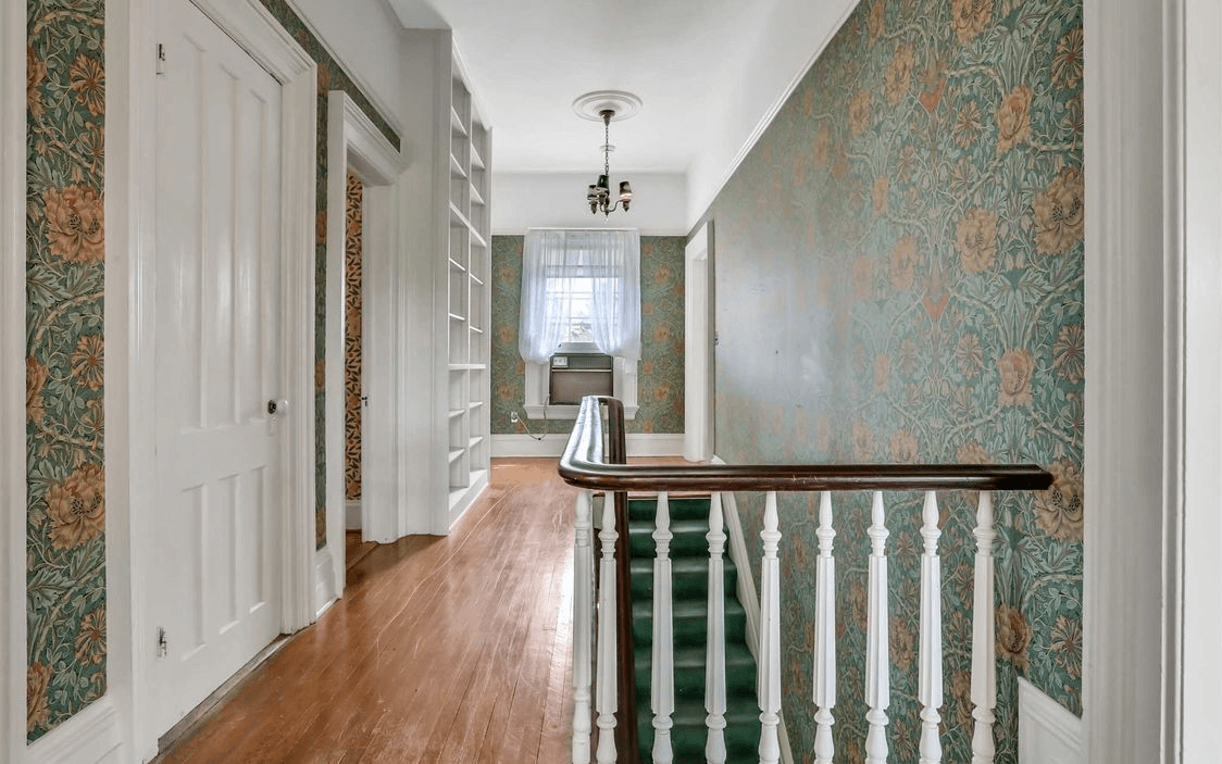 upstairs hallway with floral wallpaper