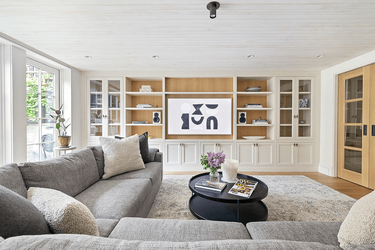 living room with wood ceiling and wall of built-ins