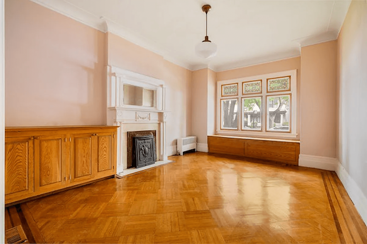 parlor with a white painted mantel and wood floor