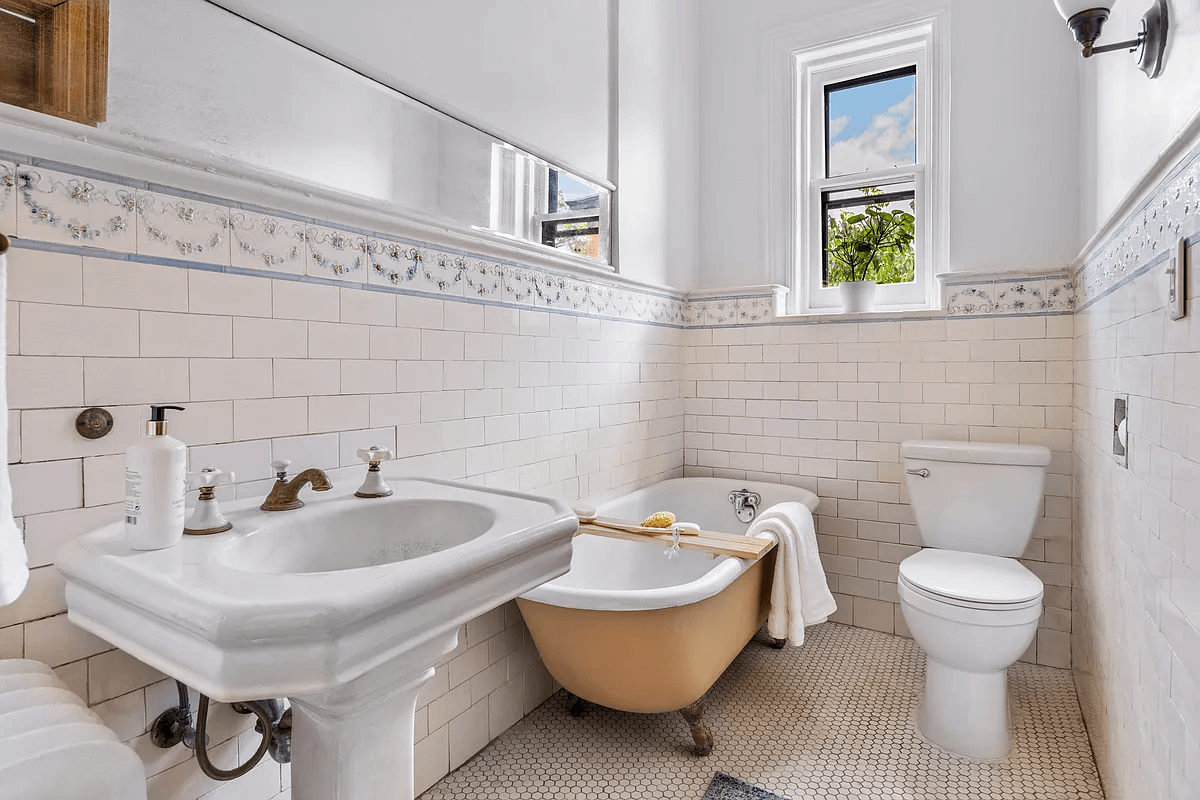 bathroom with original border tile and a claw foot tub