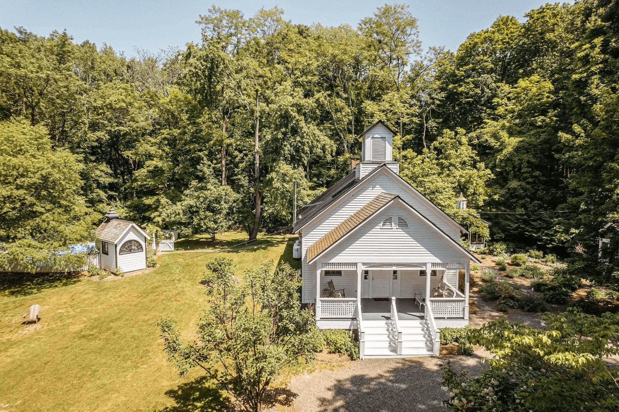 schoolhouse - view of the white painted main building and a glimpse of the in ground pool