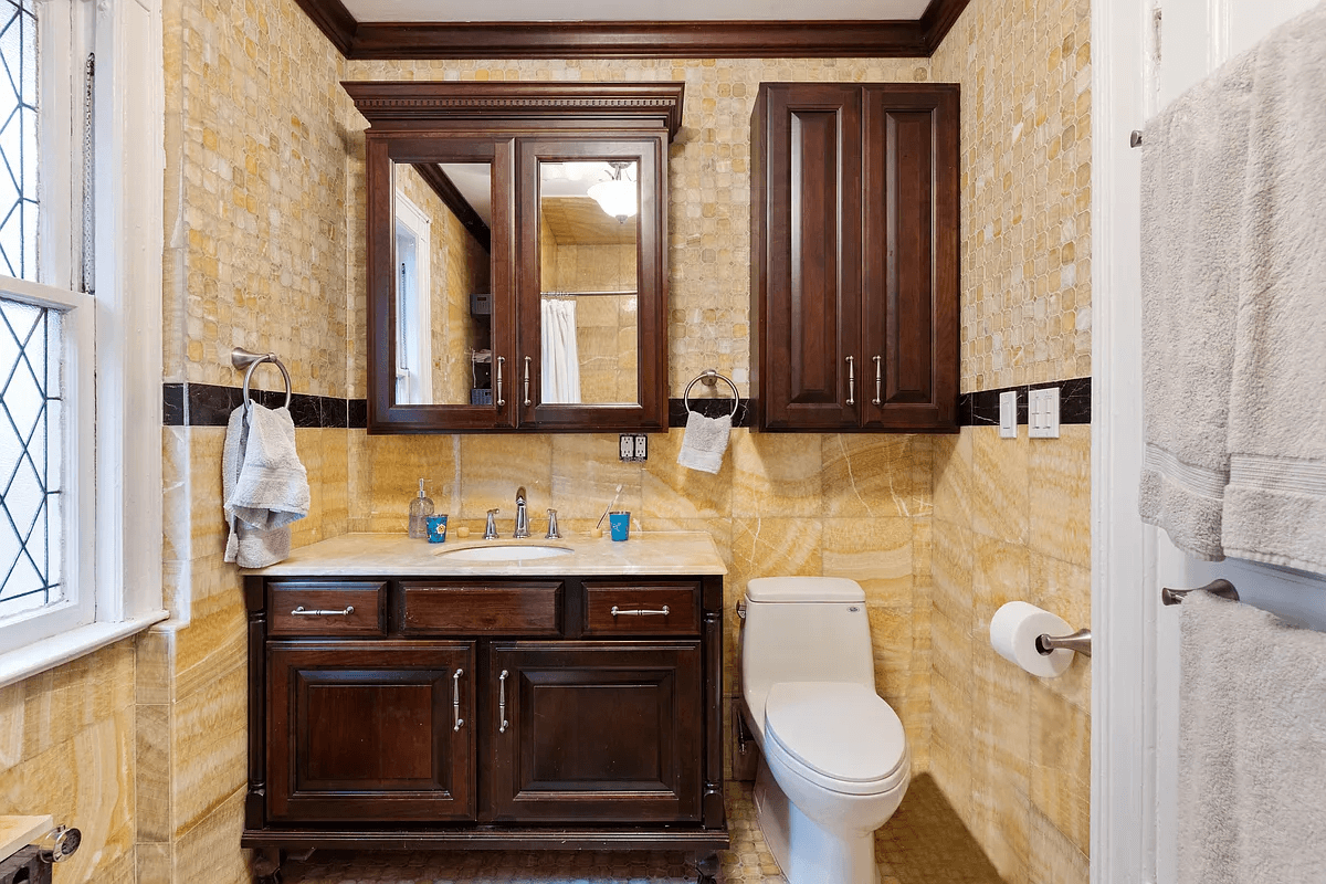 bathroom with yellow tile walls and wood vanity