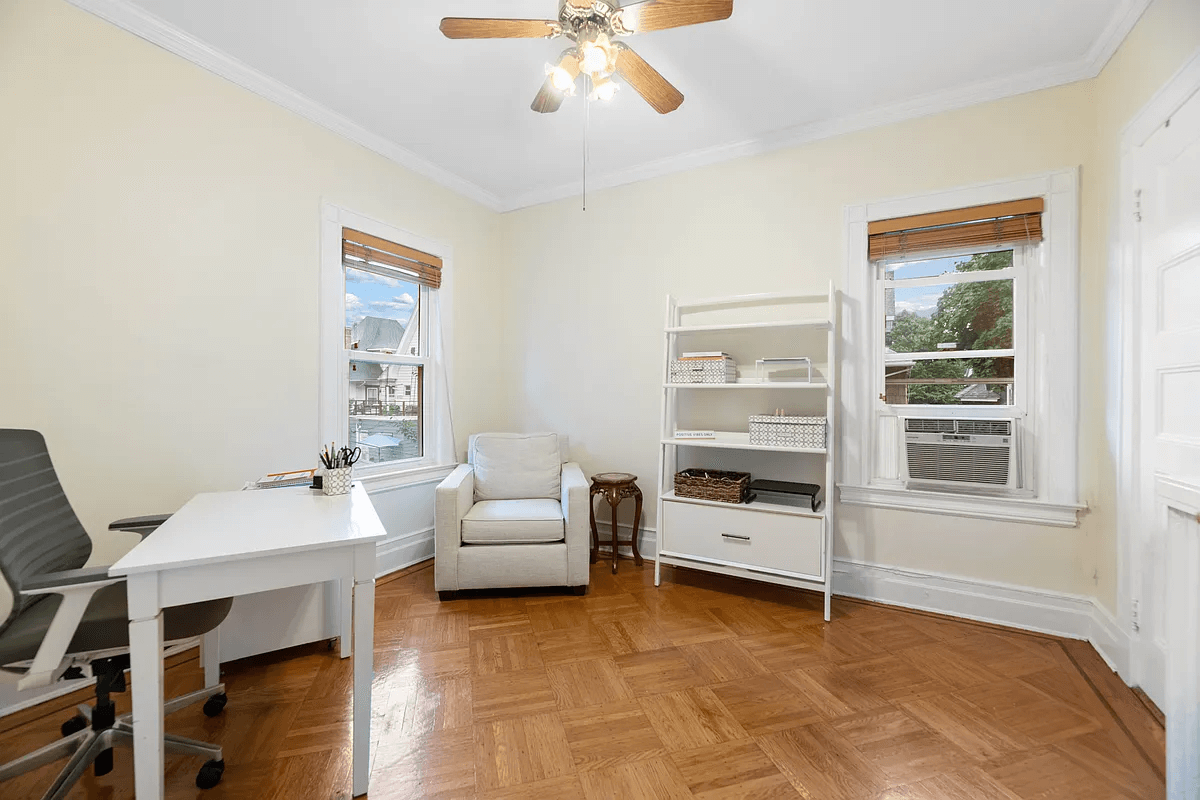 bedroom set up as an office with a ceiling fan