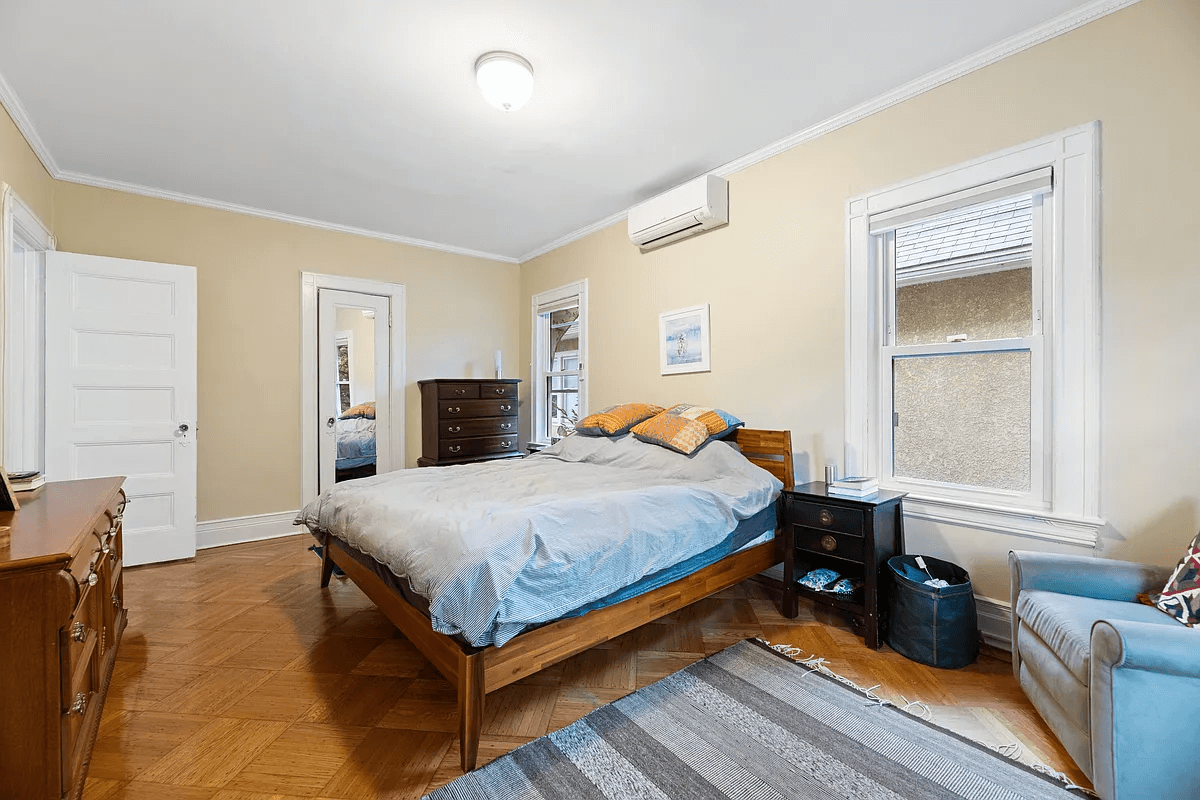 bedroom with wood floors and two windows