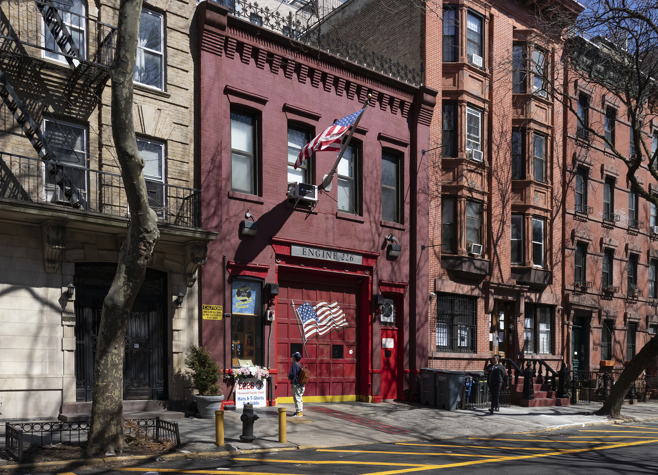 people walking by the brick firehouse