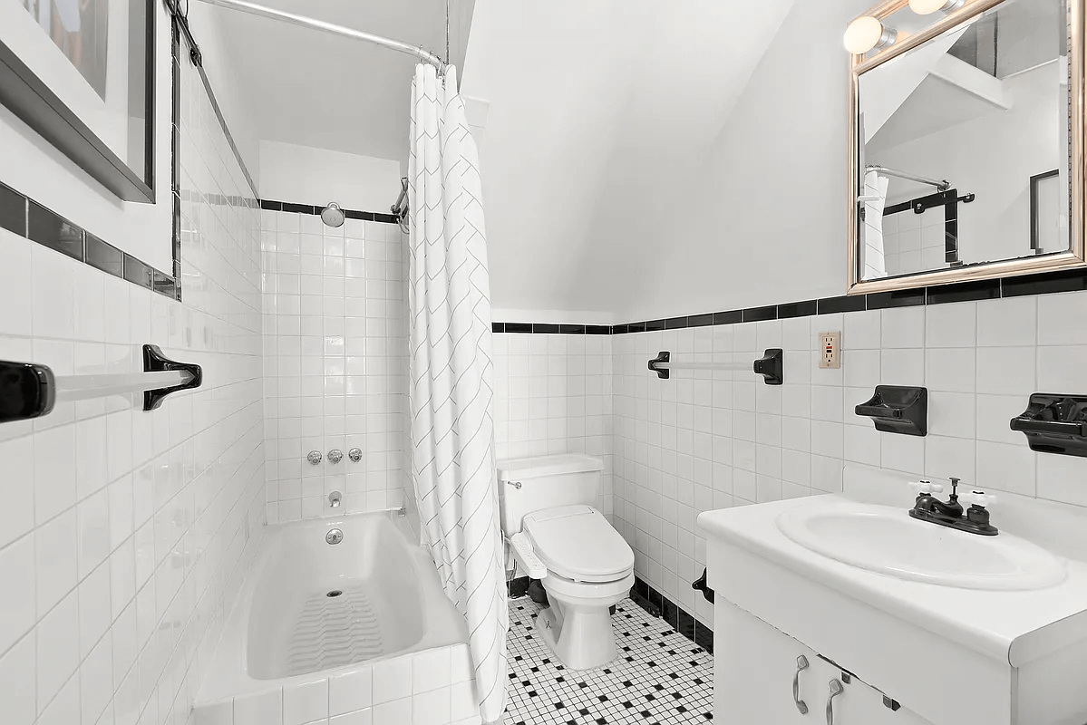 bathroom with white wall tile and black borer tile and accessories