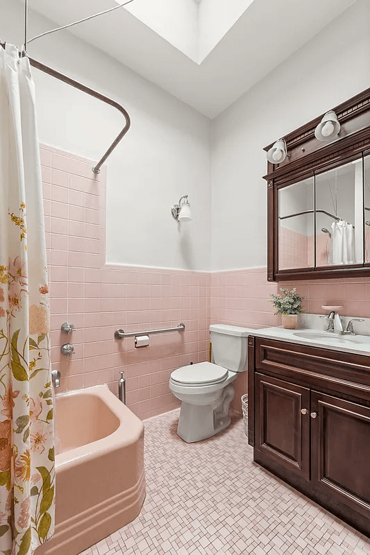 bathroom with pink tub and wall tiles