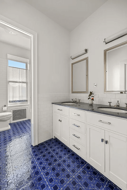 bathroom with bright blue tile floor and a double vanity