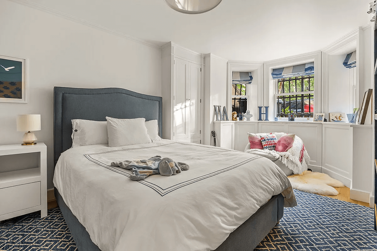 garden level bedroom with bay window and view of street