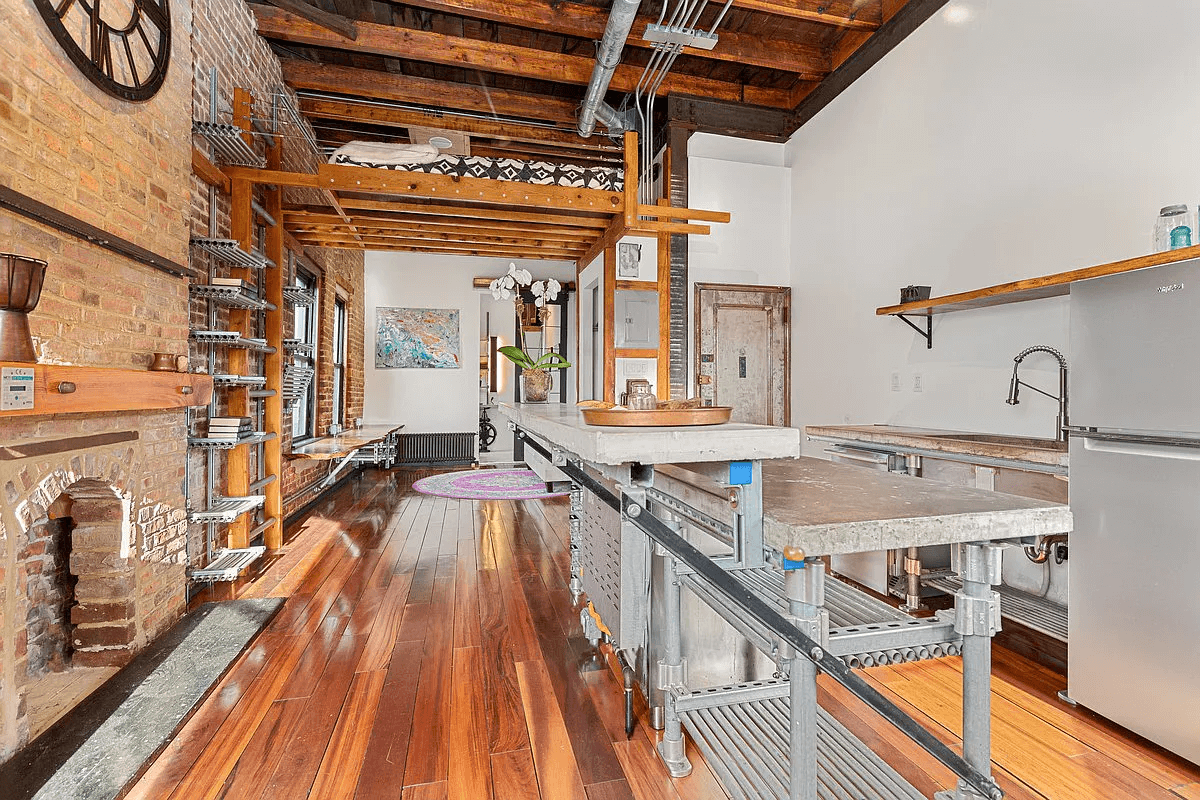 kitchen with lofted bed and exposed brick wall, industrial shelving