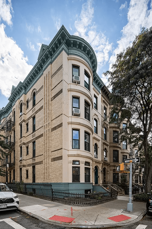 corner building exterior with pale brick and bracketed cornice