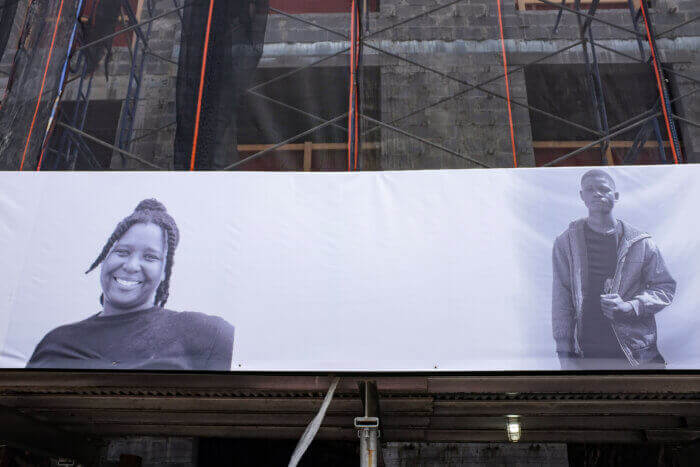 black and white portraits on a construction fence