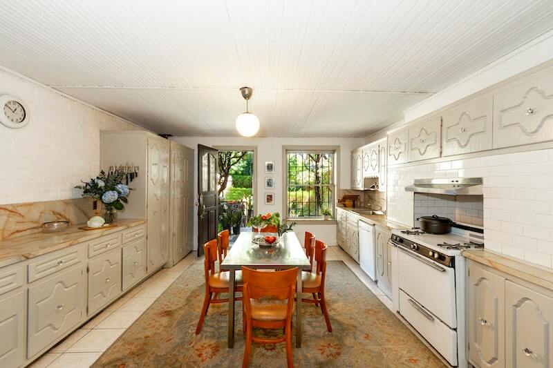 kitchen on garden level with painted cabinets and white subway tile