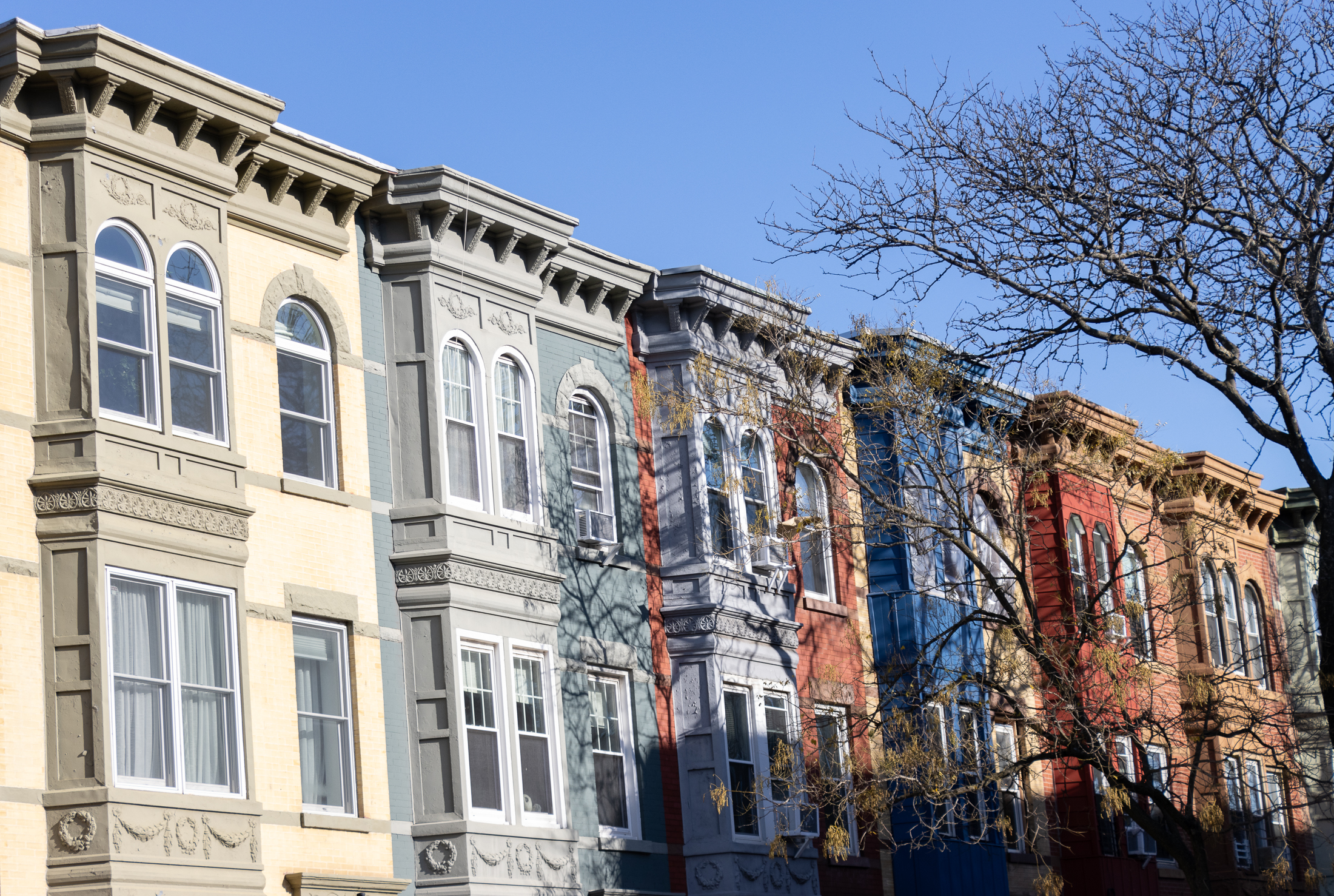 upper floors of multi-colored brick row houses with projecting bays