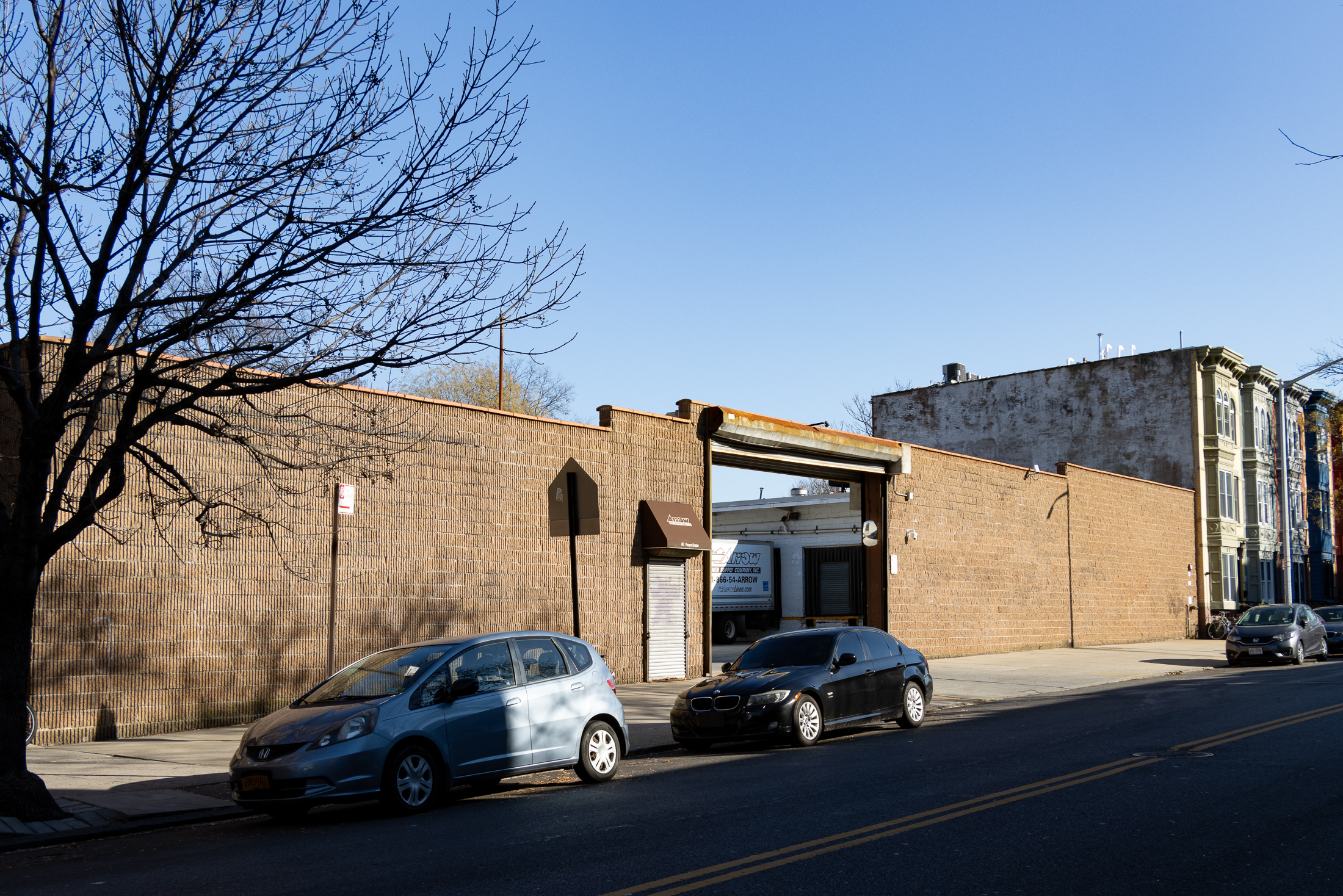 view of brick walled parking area with row houses adjoining