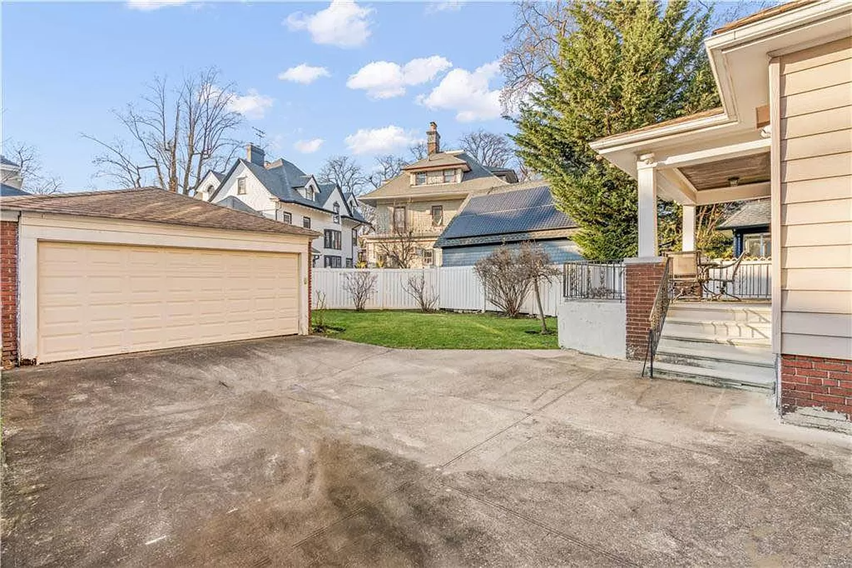 garage with view of yard and steps up to porch