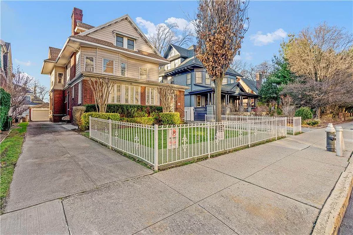 exterior with white metal fence around yard