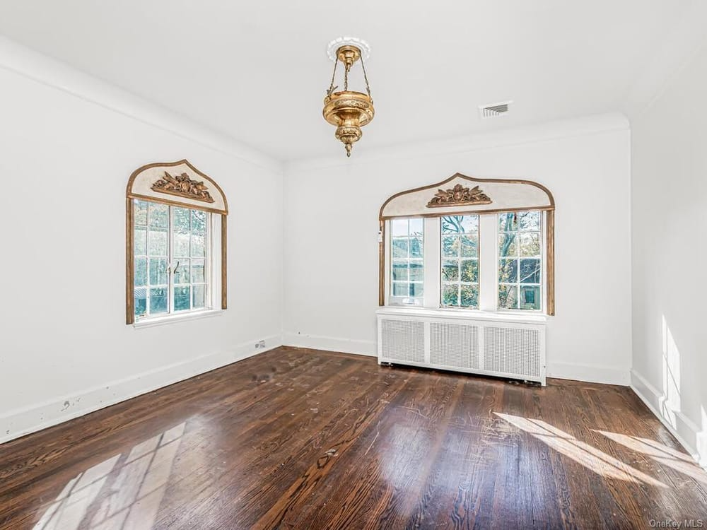 bedroom with wood floor and ornamental details above windows