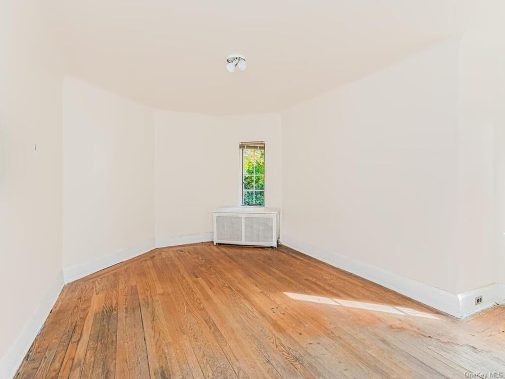 bedroom with wood floor and small window