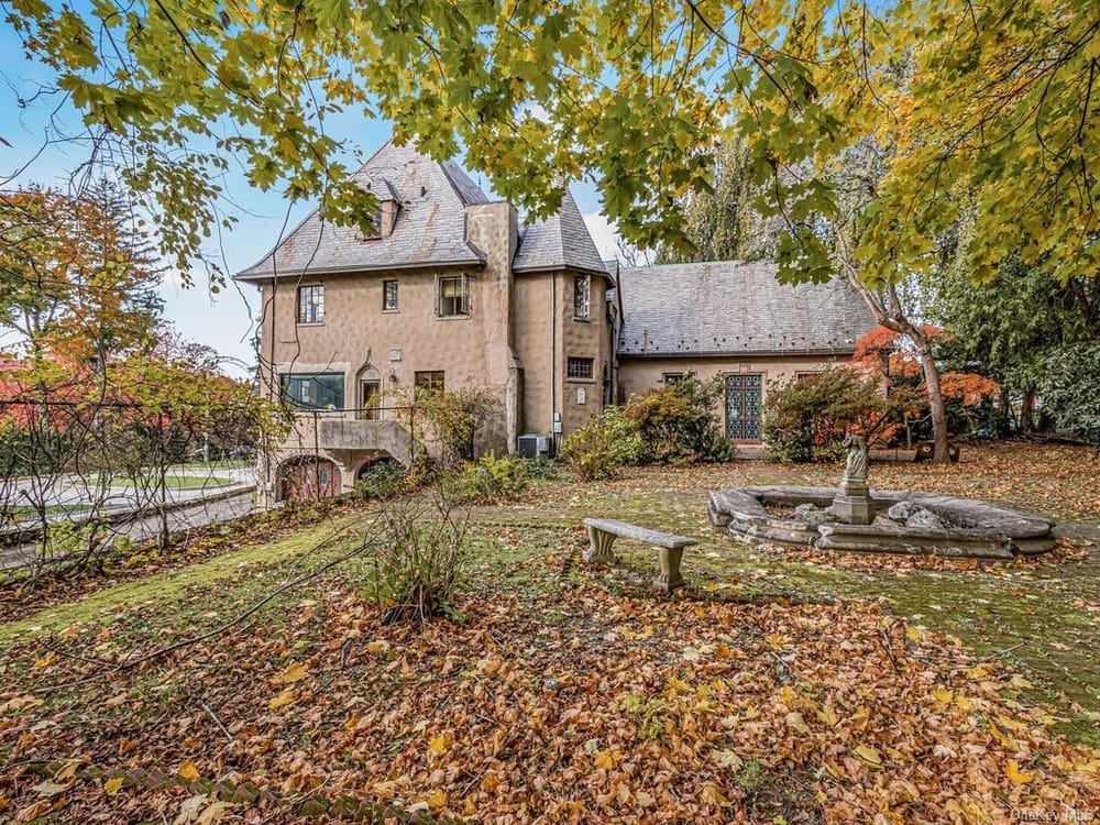 view from garden with stone benches and a pond