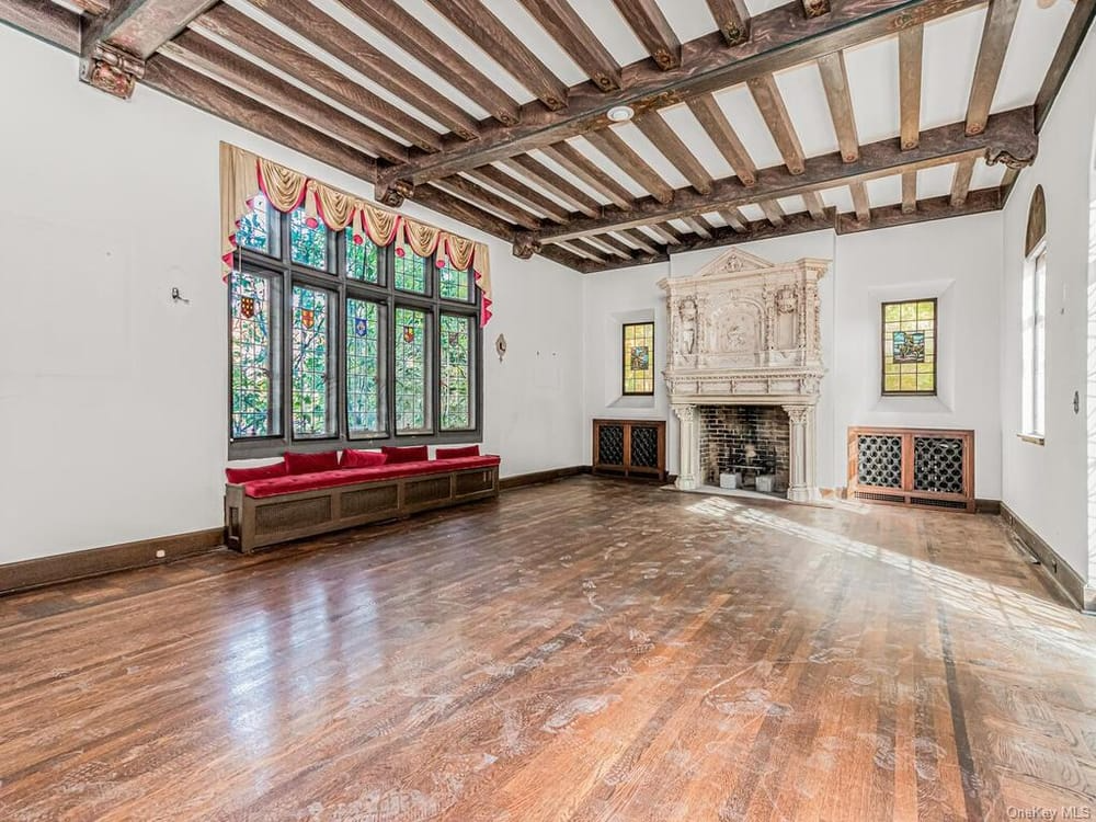 living room with beamed ceiling, stained glass windows and a mantel