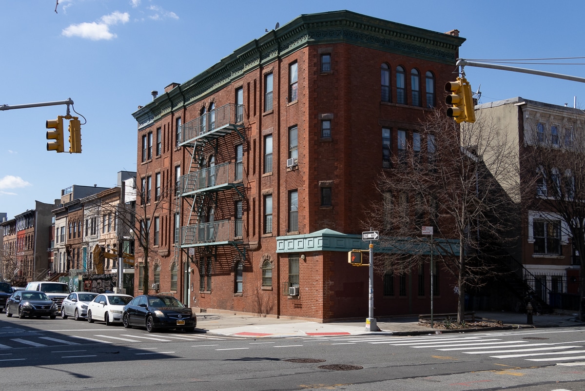 red brick flats building with green cornice