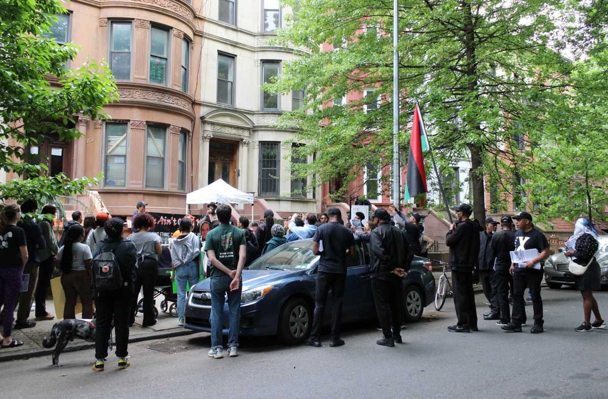 group gathered around a stoop to listen to speakers