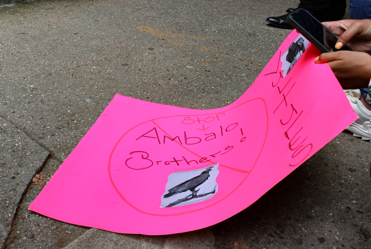 pink sign with stop ambalo brothers handwritten on it