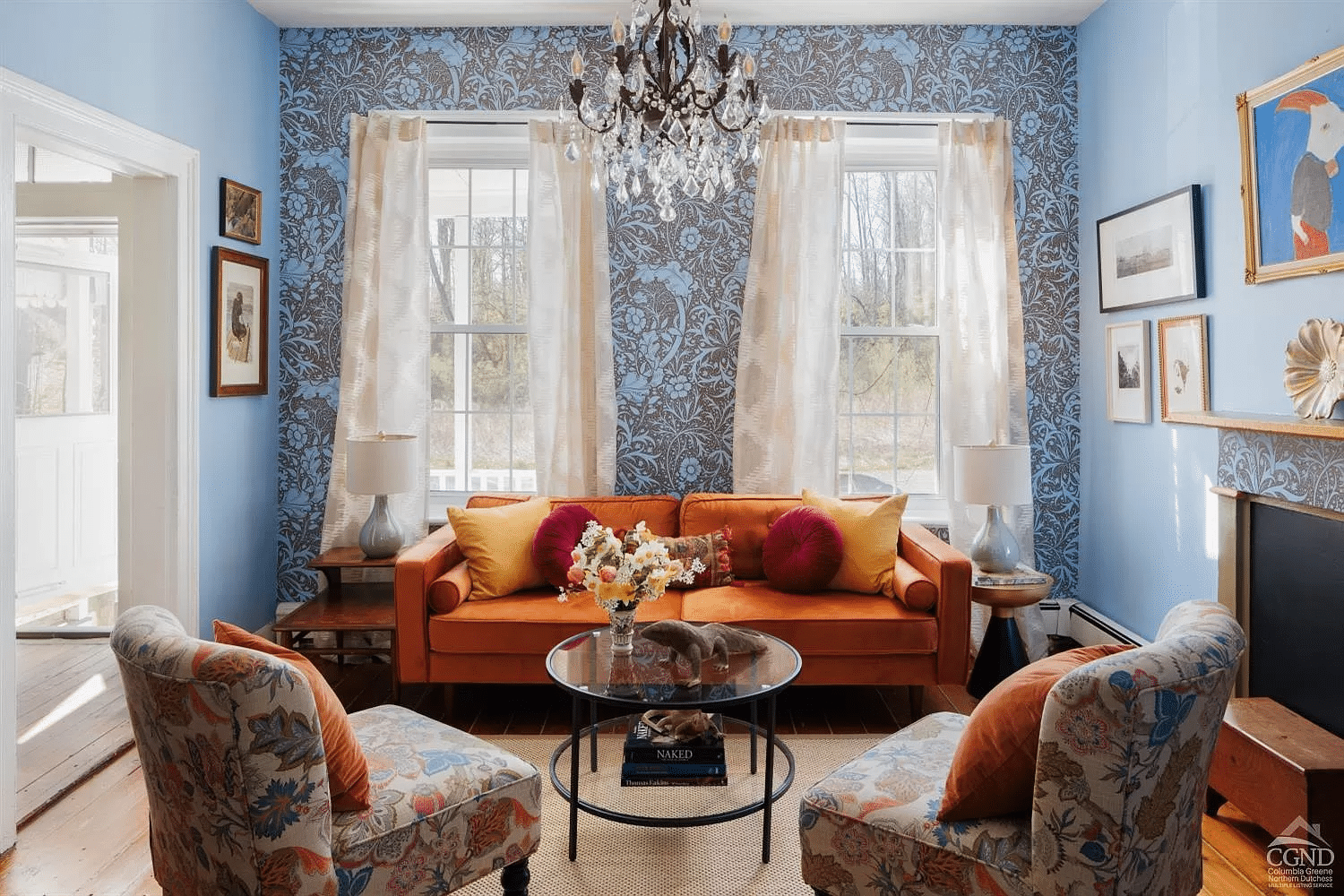 living room with blue walls and floral wallpaper, wood floor