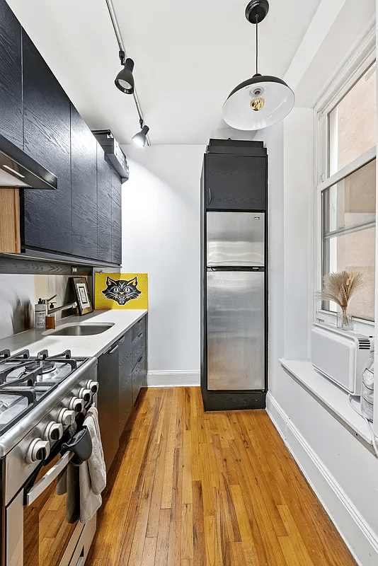 kitchen with wood floor, black cabinets