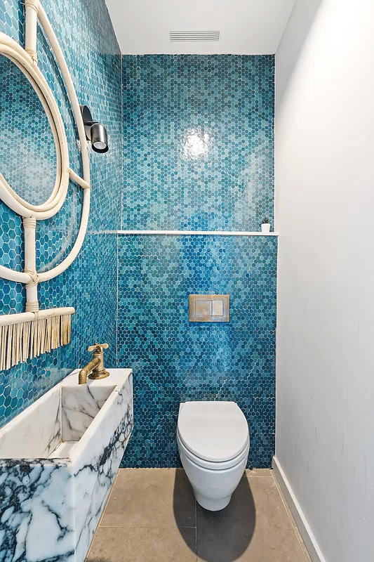 bathroom with blue hex tiles on the walls and a floating vanity