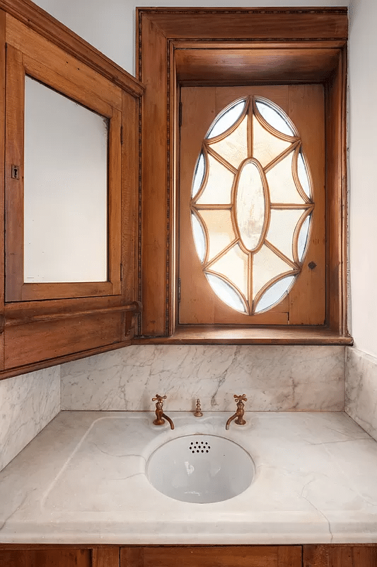 bathroom with marble sink and wood trimmed window