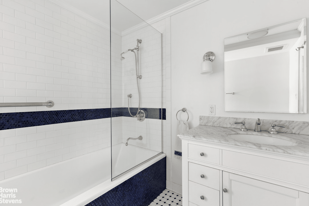 Bathroom with white fixtures and black and white tiles