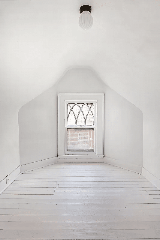 low ceilinged room with white walls and floor