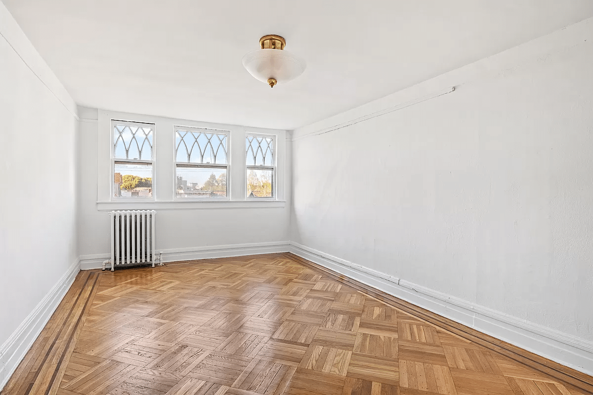 bedroom with wood floor, three windows