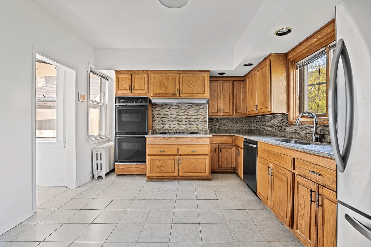 kitchen with beige tile floor, wood cabinets and a dishwasher