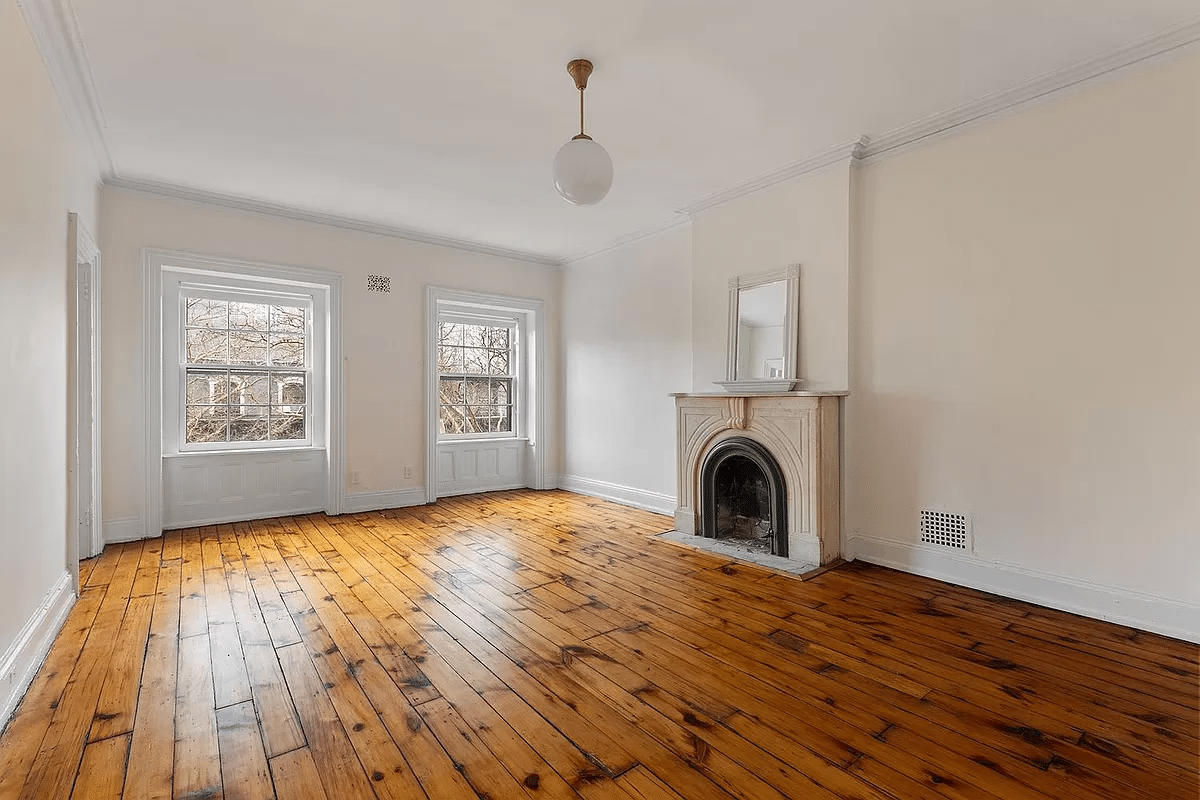 bedroom with wood floor and marble mantel