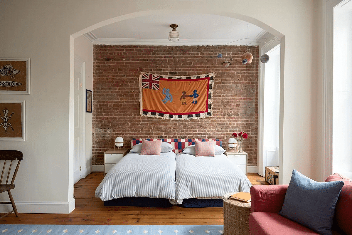 niche in bedroom with exposed brick wall, room for two twin beds