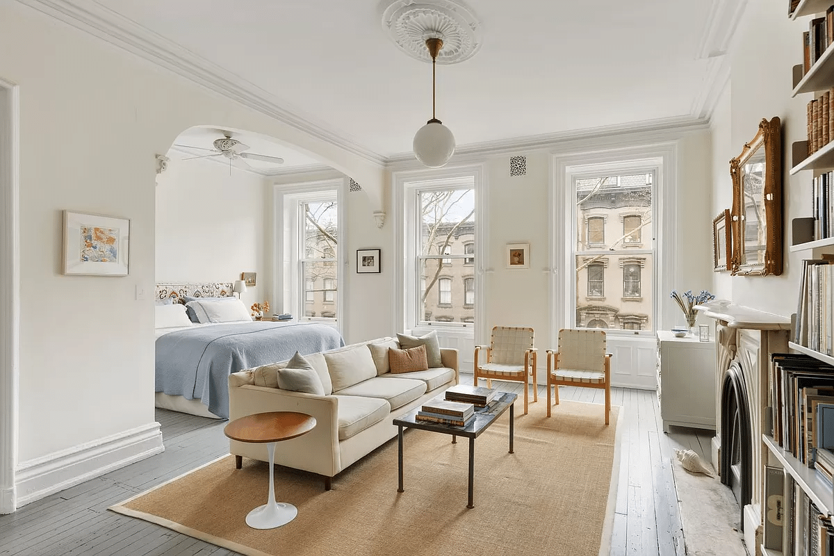 bedroom with bed niche, sitting area and marble mantel