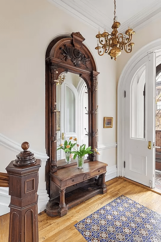 entry with arched, double doors, mirror, and original stair