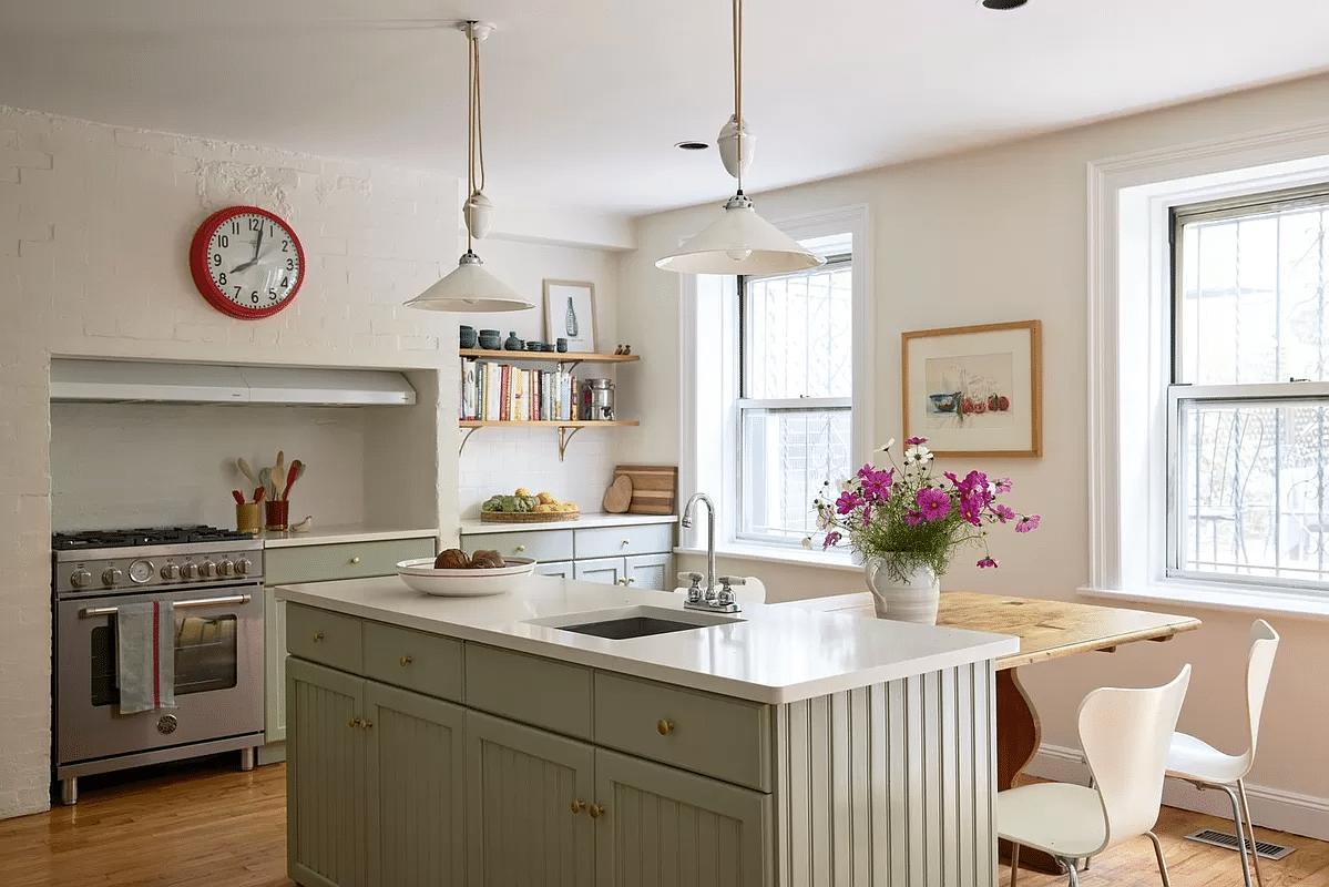 kitchen with sage green lower cabinets and island, open shelves and white walls