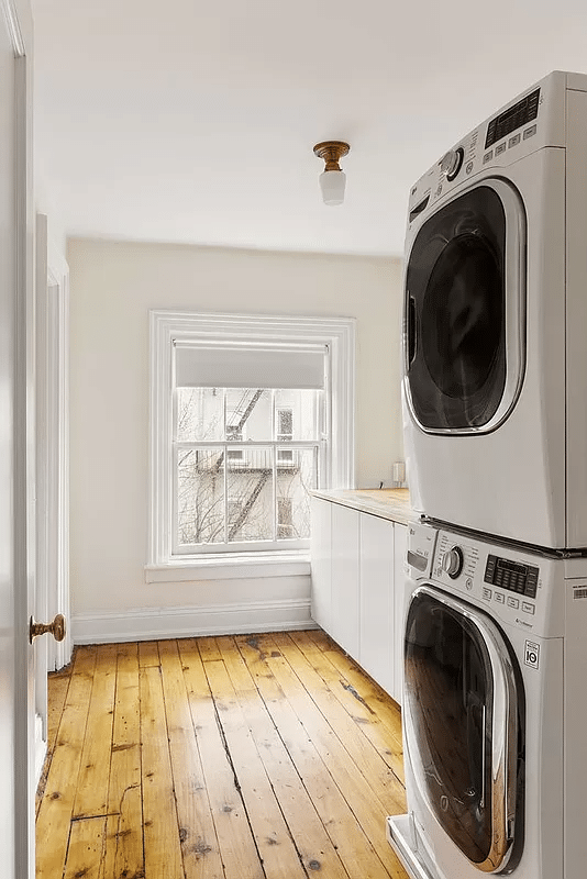 laundry room with stacked washer and dryer, counter space and cabinets