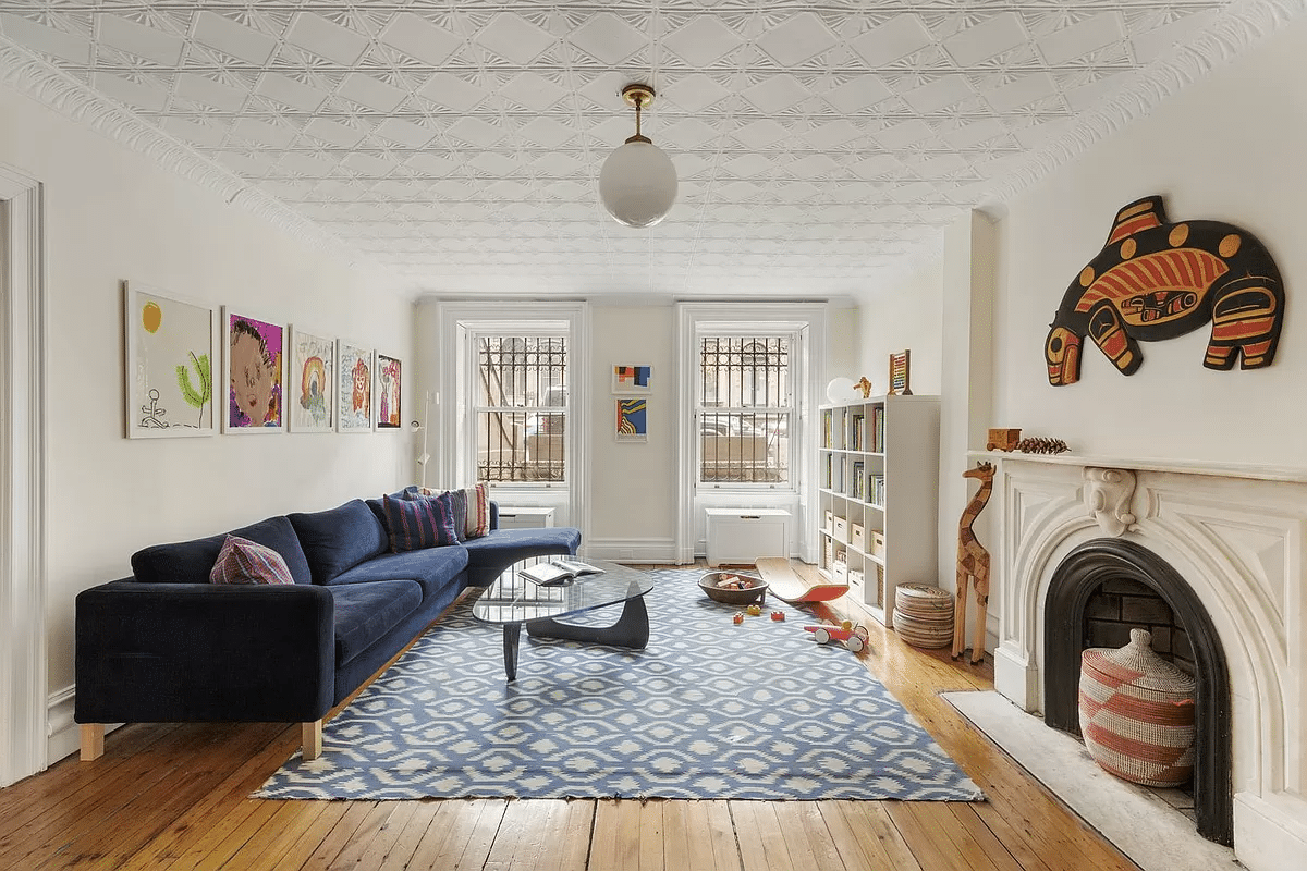 play room on garden level with tin ceiling, marble mantel and wood floor