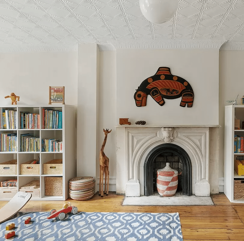 play room on garden level with tin ceiling, marble mantel and wood floor