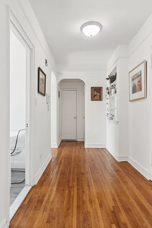 foyer with niche with shelves, wood floor