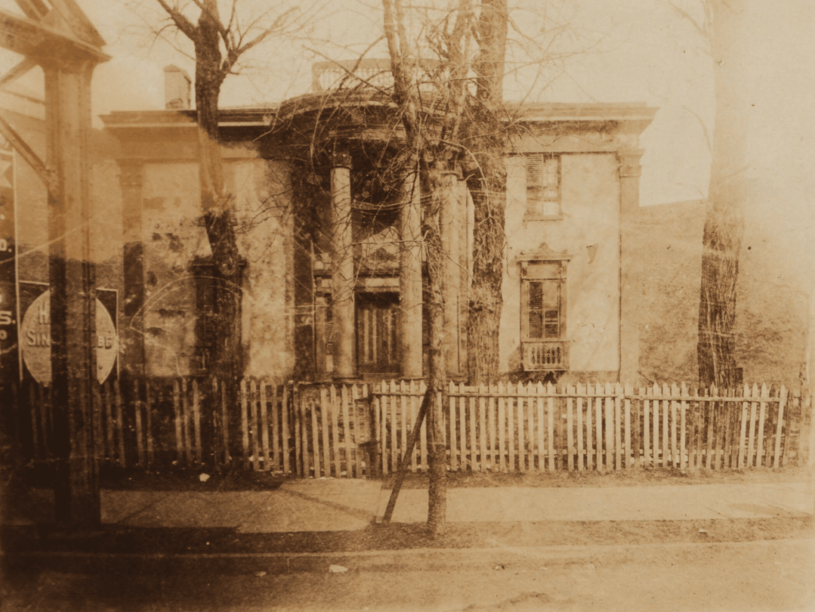 black and white photo showing house with columned portico