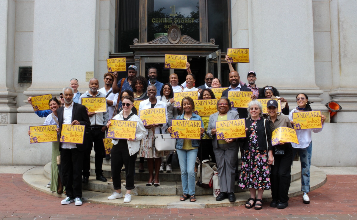 bed stuy - supporters for the proposed district posing with "landmark bed stuy" signs