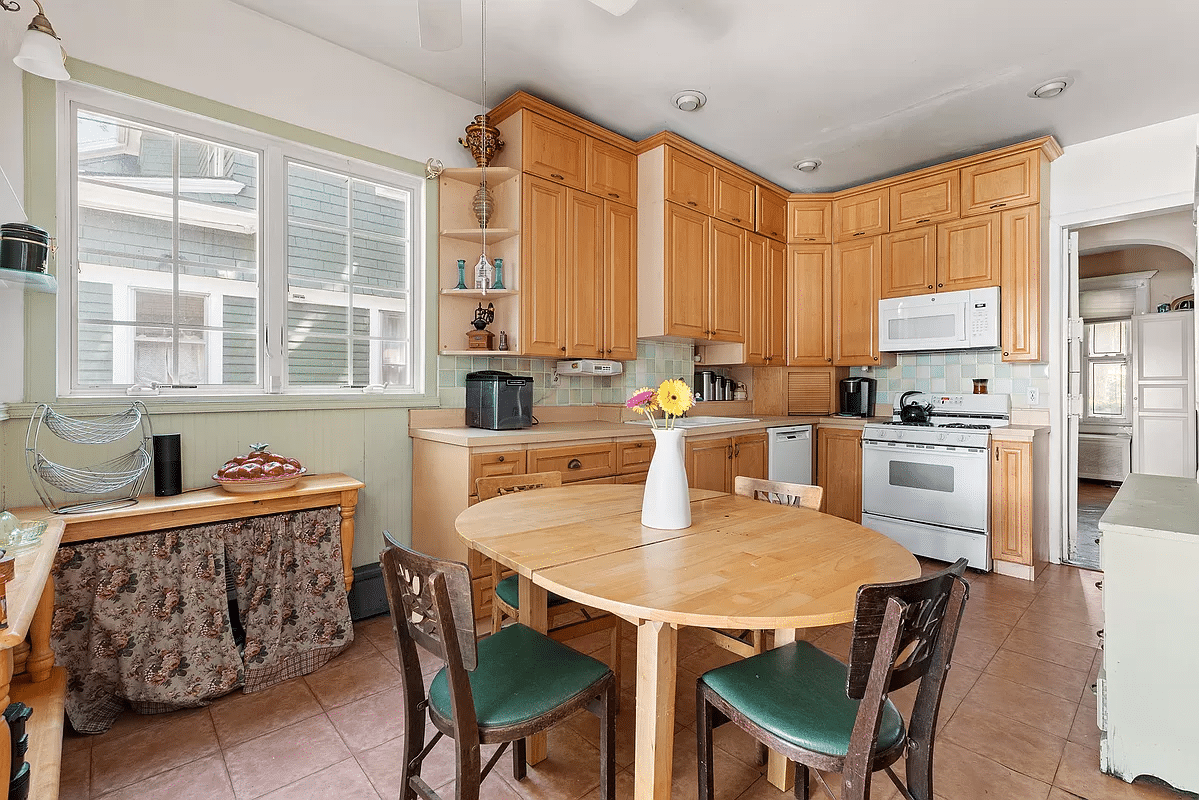 windowed kitchen with wood cabinets, tile floor